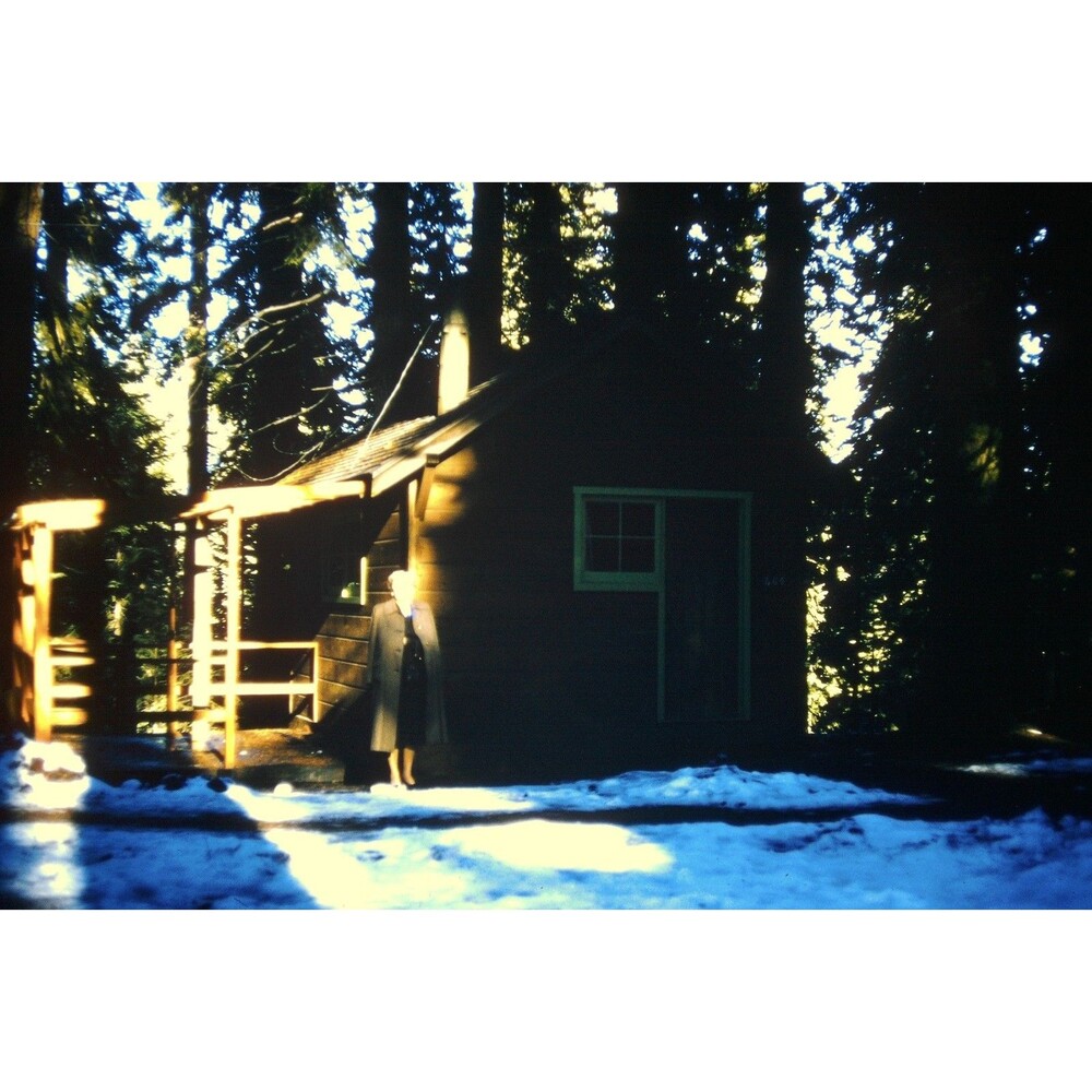 Kodak 35mm 1950s Red Border Kodachrome, person standing beside a wooden cabin